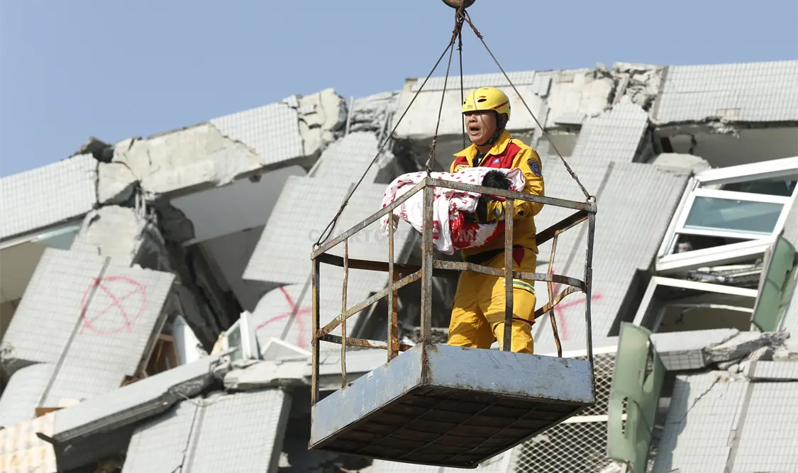 Un rescatista sostiene el cuerpo de una de las víctimas del terremoto. AP