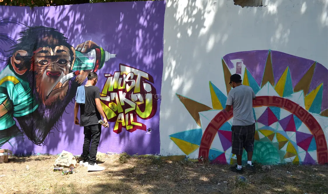 Artistas urbanos pintando las paredes de las casas. María Perianza / CP