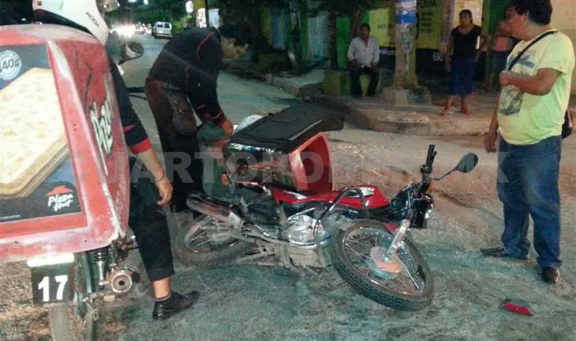 La motocicleta derribada. Un compañero pizzero observa la escena. A. Alegría / CP