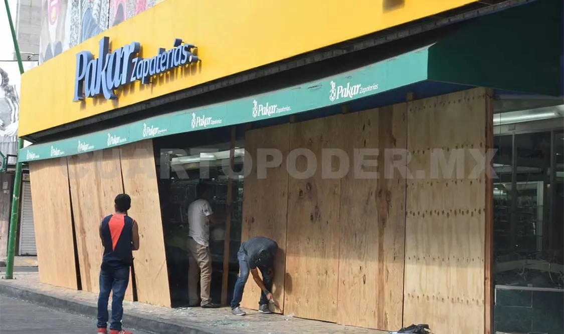 En algunos comercios, grupos de trabajadores instalan muros de tablas para protegerlos. Rafael Victorio / CP