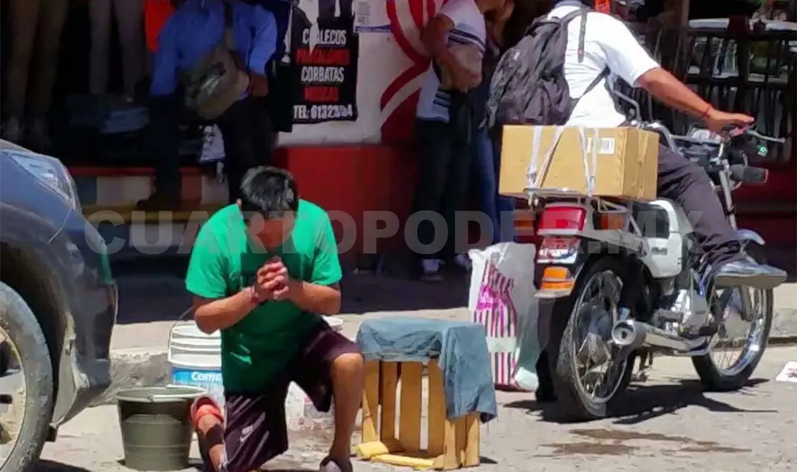Luego de hacer la señal de la cruz, Lucas toma su cubeta con agua, su franela y comienza a limpiar una camioneta. Avisaín Alegría / CP