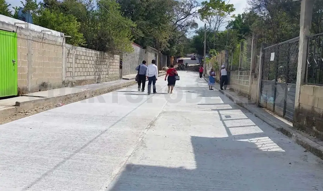 Colonos felices por calle pavimentada