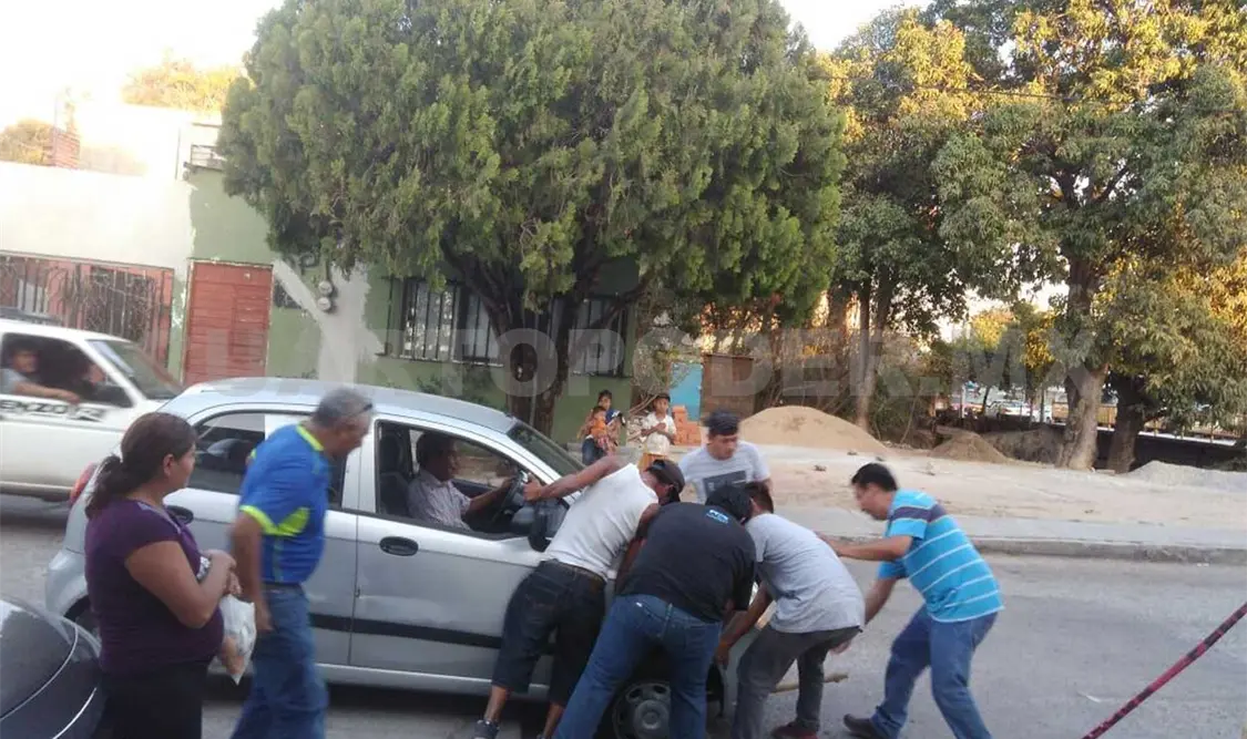 Caen autos una y otra vez en calle sin rejilla