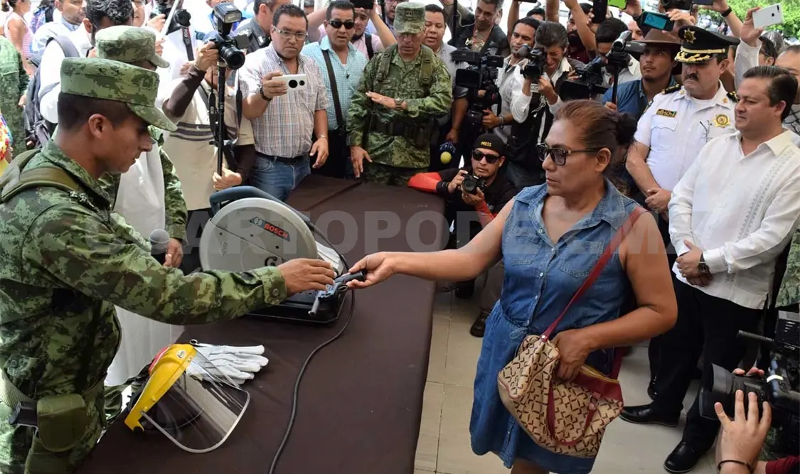 Una mujer pone la muestra en canje de armas
