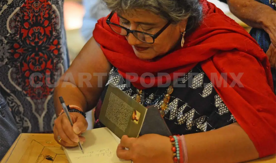 Chary firmando su antología Como pluma de pájaros. Darwin Mendoza