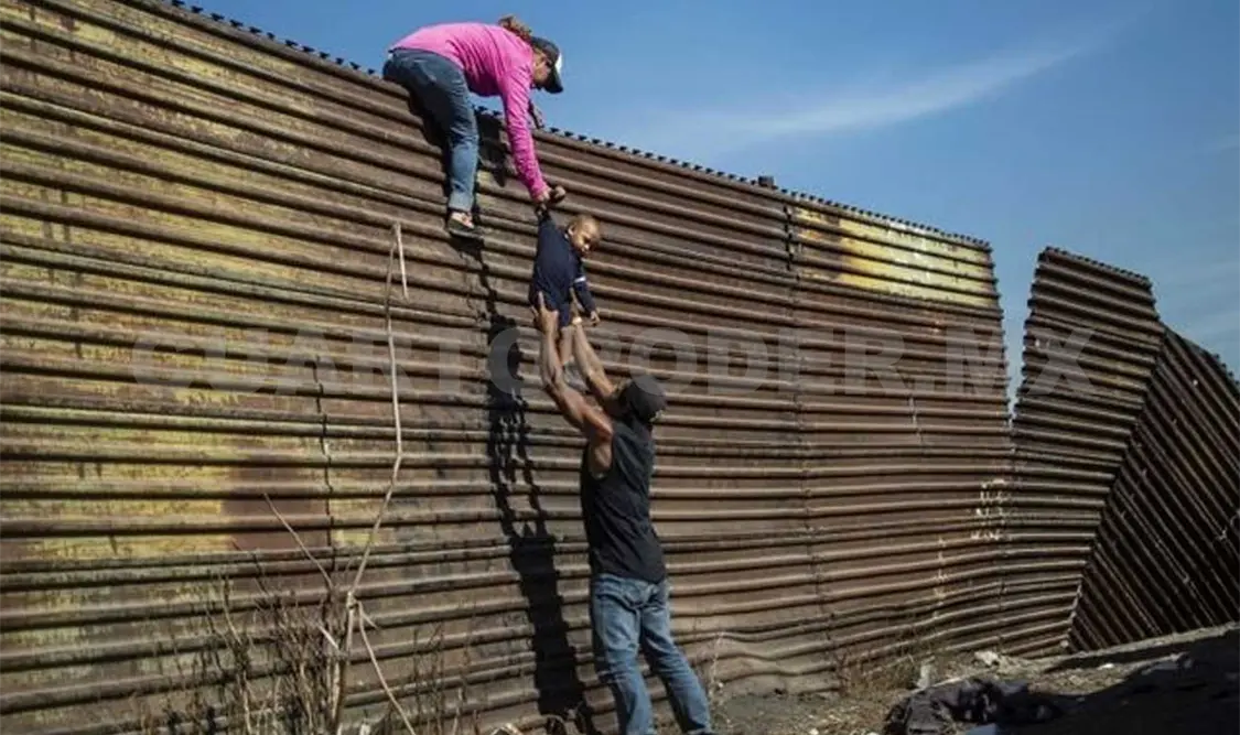 La fotografía muestra a una familia que intenta cruzar el muro fronterizo entre México y Estados Unidos. Cortesía