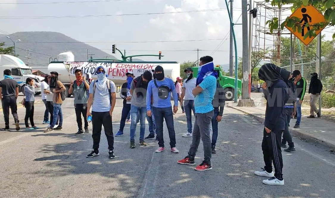Normalistas vandalizan vehículos privados