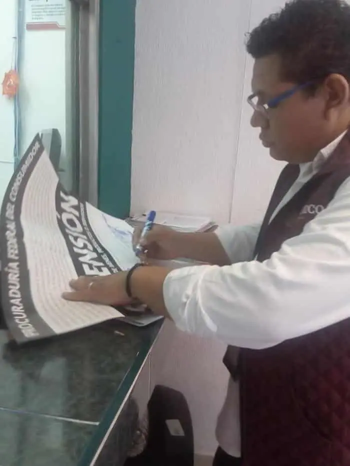 Personal de la delegación de Profeco en la colocación de sellos de suspensión. CP