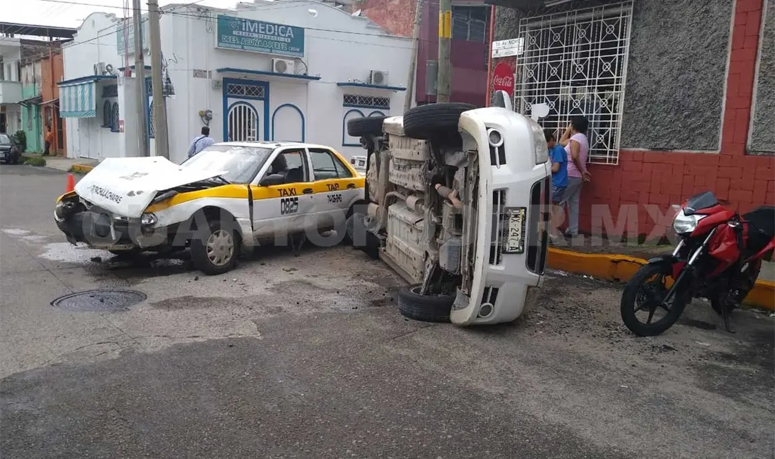 Taxi choca y causa volcadura de Aveo