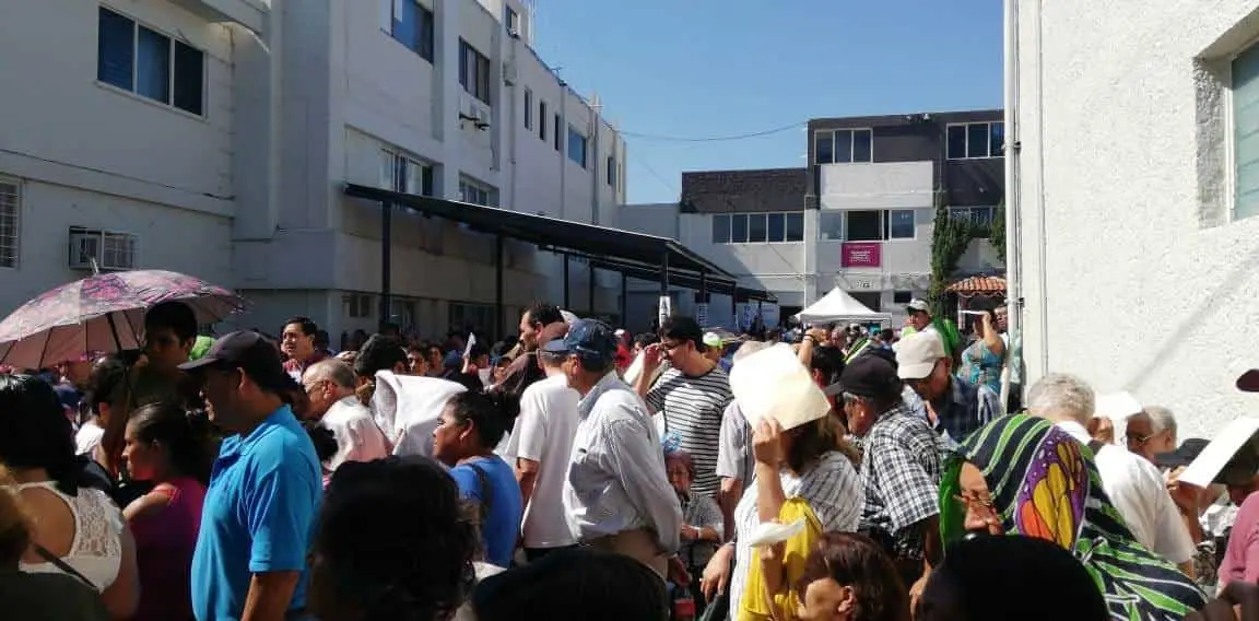 Bajo el sol hacen largas filas los adultos mayores para que les entreguen su ficha para poder ir a cobrar el apoyo. CP