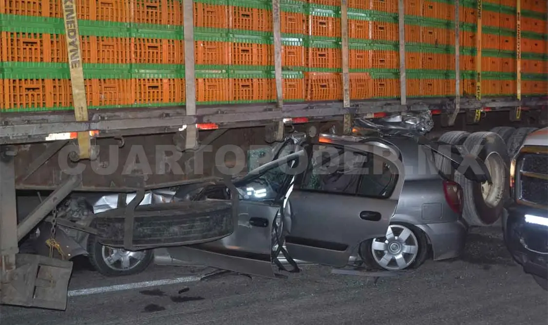 Fallece mujer al quedar su auto debajo de tráiler