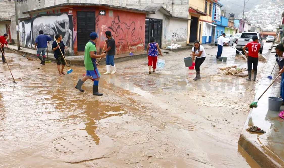 En el barrio Tlaxcala, familias limpian el lodo que ocasionó el desborde del río aledaño. Diego Pérez / CP