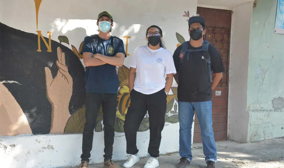 Los Conejos del Mictlán posando junto a la obra de Harto Peralta. Cortesía