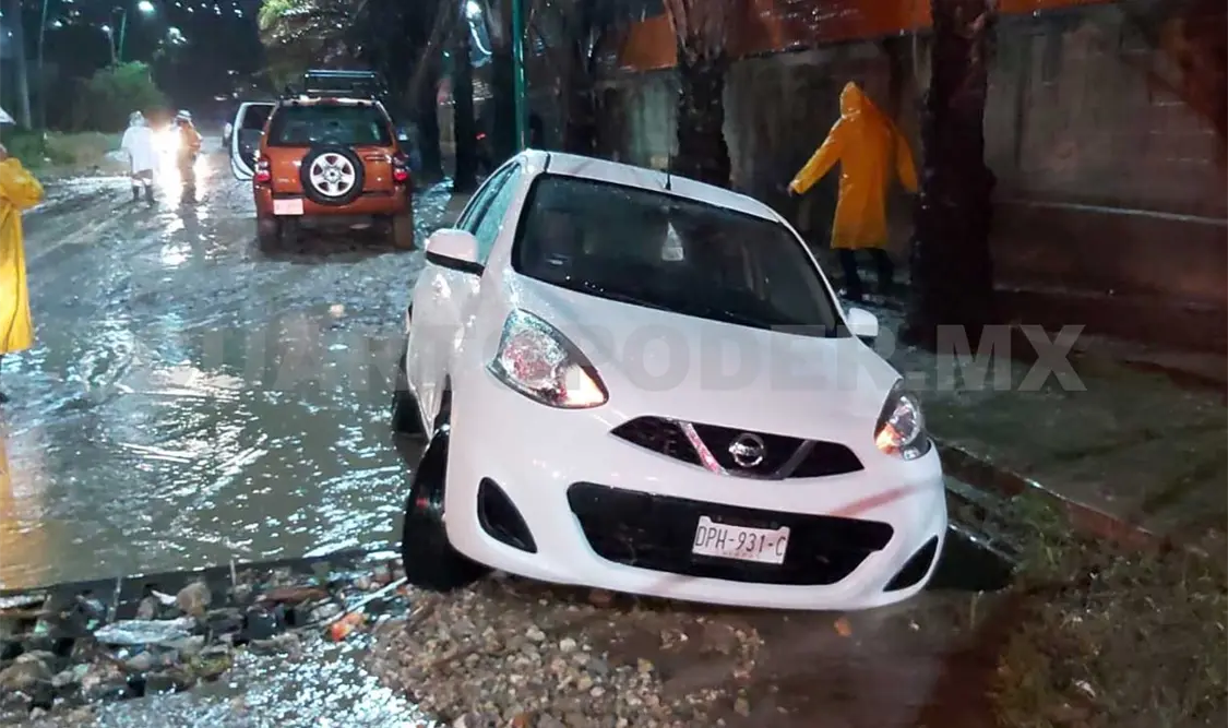 Dos de los tripulantes de un Nissan March intentaron rescatar la unidad al caer en la alcantarilla rota, pero fueron arrastrados y sumergidos por la corriente. Ulises López / CP