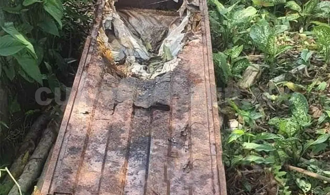 Hallan cuerpo en ataúd en medio del camino