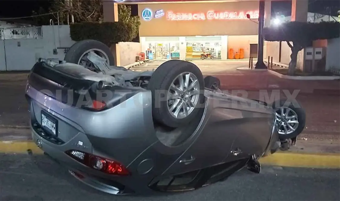 Vuelca automóvil y derriba luminaria
