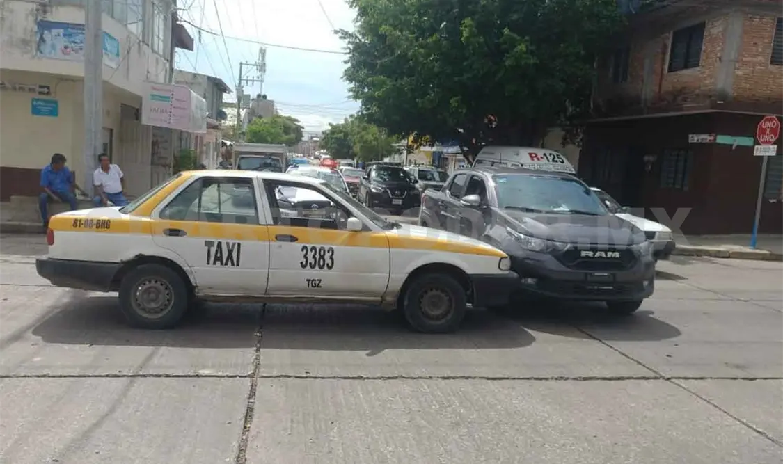 Taxi y Pick up chocan sobre un cruce de calles