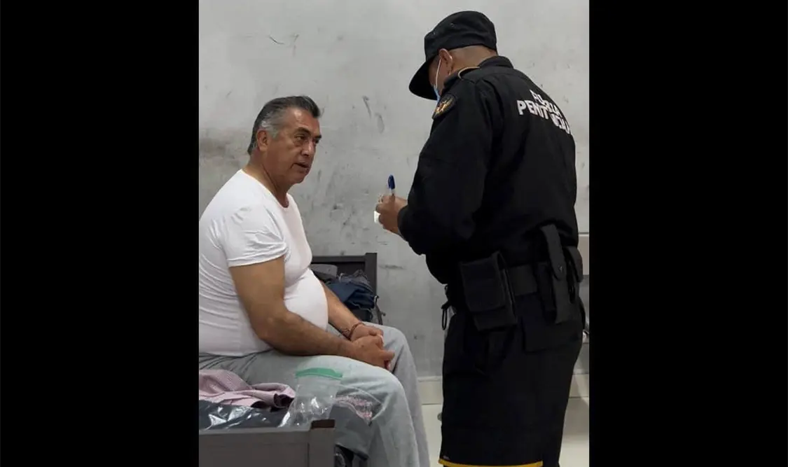 En una foto divulgada se ve al exmandatario vistiendo una camisa blanca, pantalón gris y sentado en una celda, al mismo tiempo que es cuestionado por un policía. Cortesía