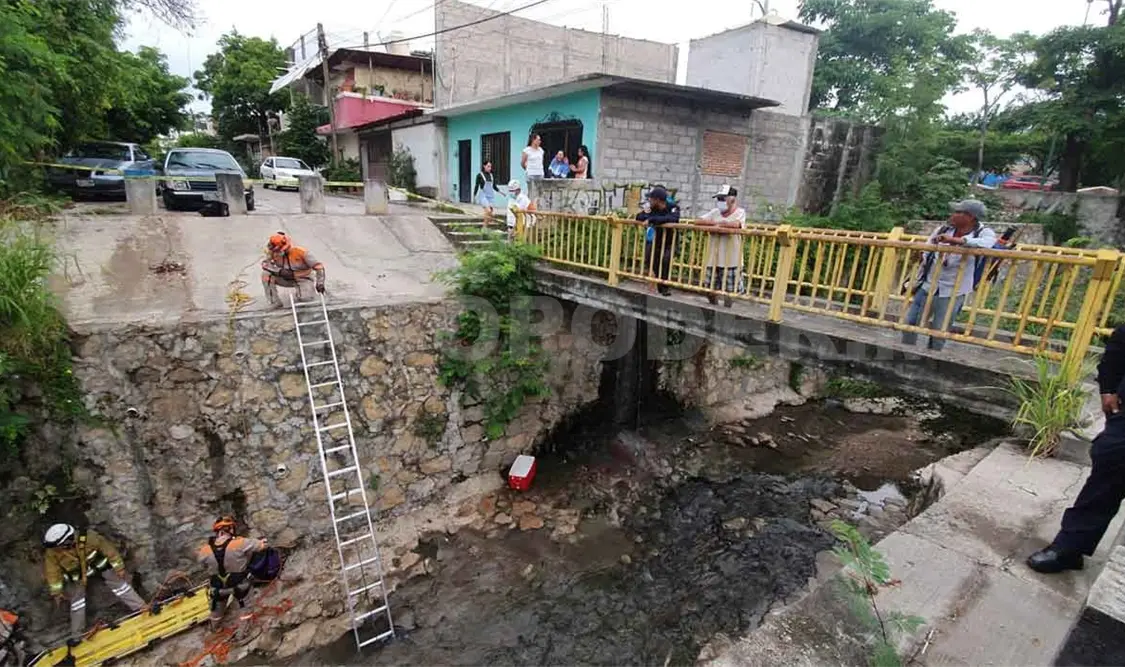 Cae con todo y motocicleta a un canal de aguas negras