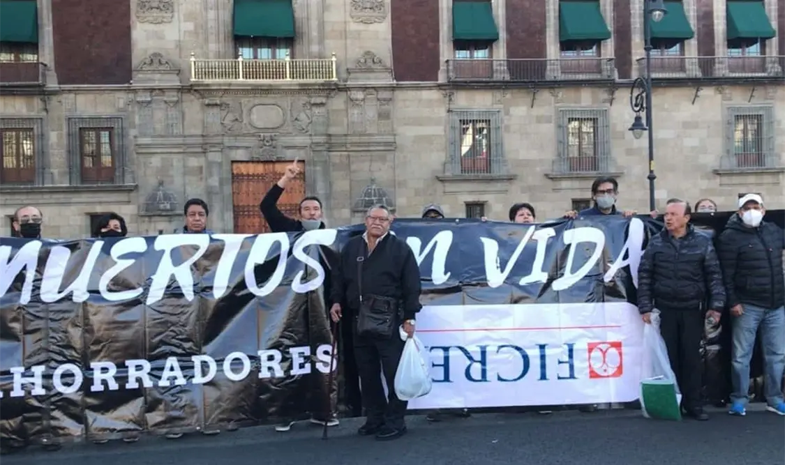 Con una manta negra que dice “Muertos en vida”, ahorradores de Ficrea se presentaron frente a Palacio Nacional. Cortesía