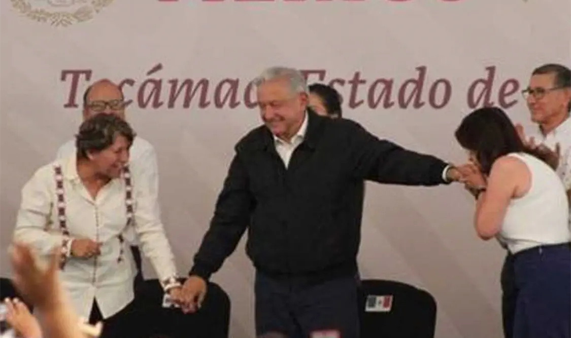 Al levantar la mano a la gobernadora y a la Alcaldesa, quien -al término de la arenga- le besó la mano al Mandatario. Cortesía