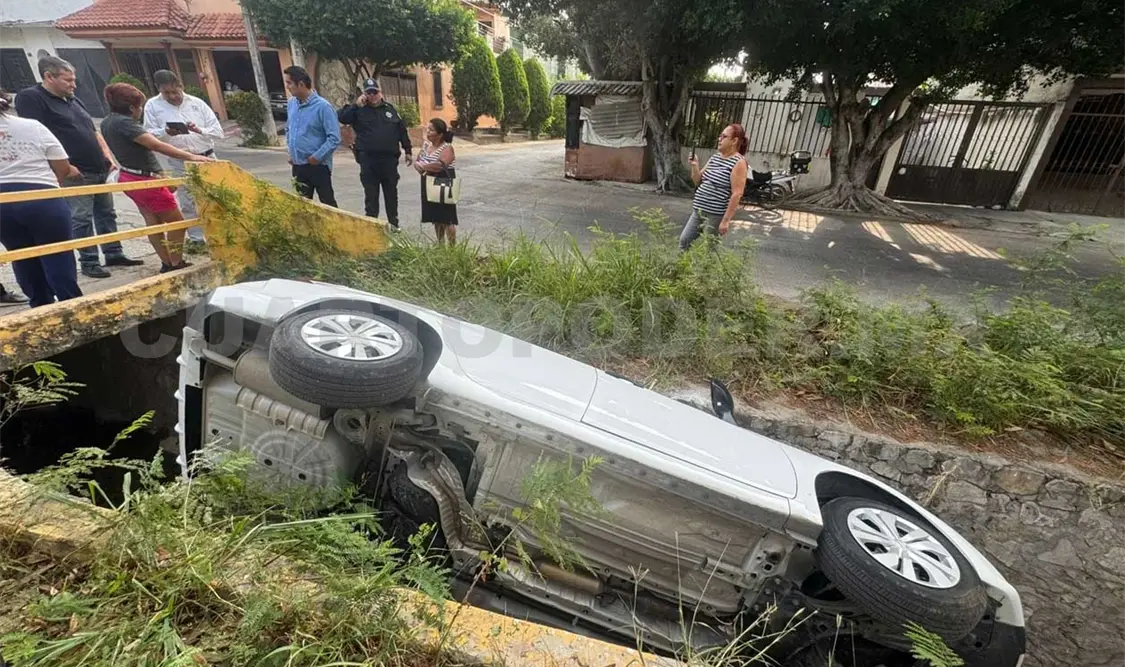 Cae sedán al fondo de canal de aguas residuales