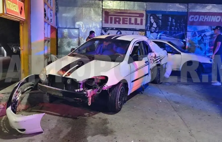 Colisionan y terminan dentro de llantera
