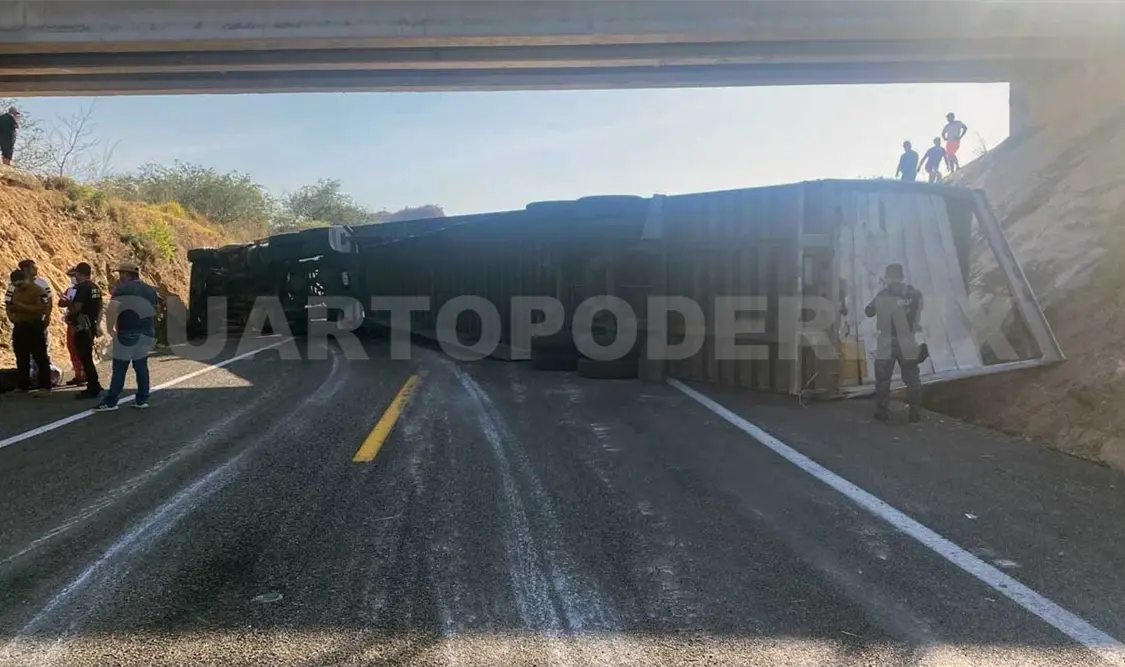 Tráiler se voltea y queda atravesado bajo un puente