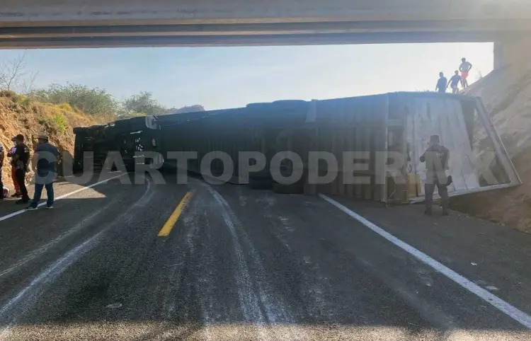 Tráiler se voltea y queda atravesado bajo un puente