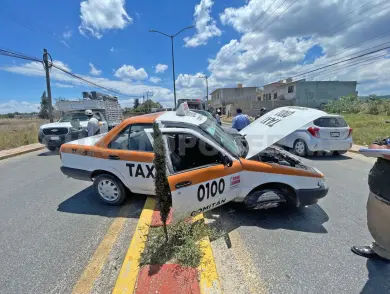 Taxi queda atrapado sobre el camellón
