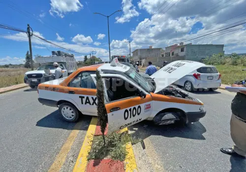 Taxi queda atrapado sobre el camellón