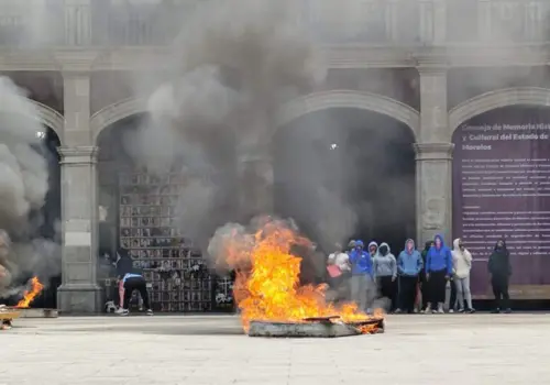 Normalistas queman tres colchones en Plaza de Armas