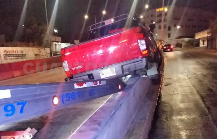 Termina camioneta atascada sobre el muro de contención