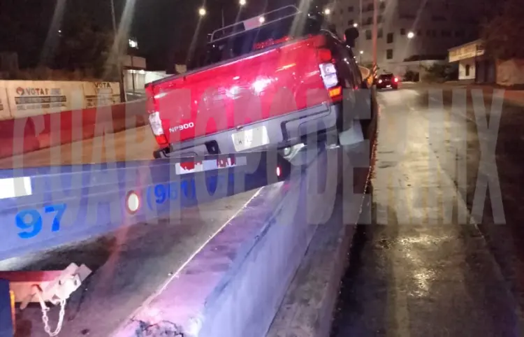 Termina camioneta sobre el muro de contención