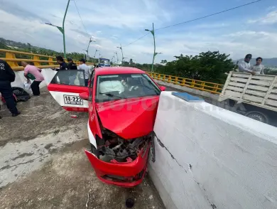 Se estrella taxi foráneo en barra de contención