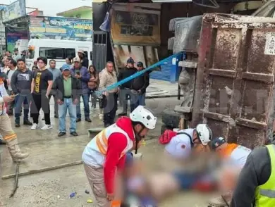 Mujer queda atrapada bajo la caja de un volteo