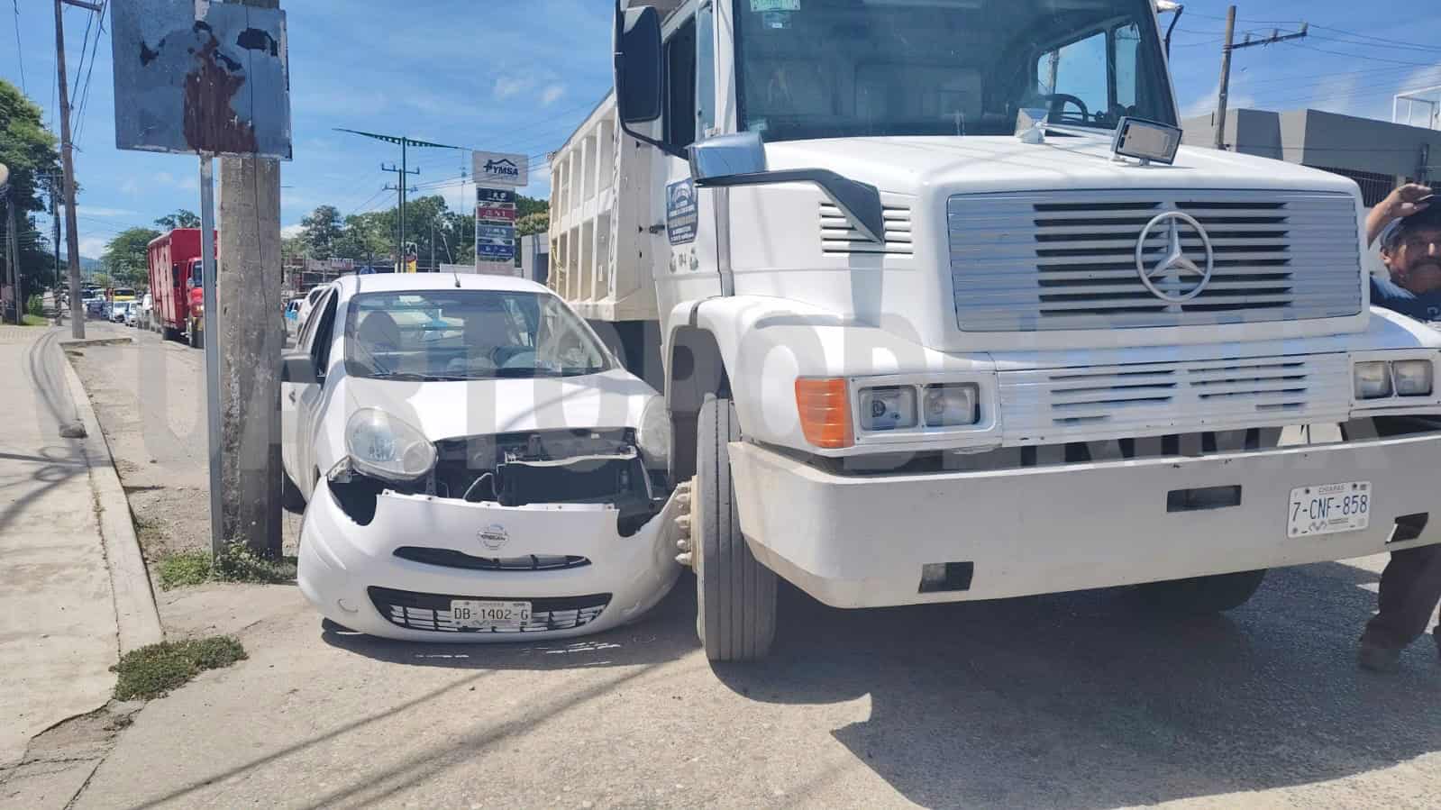 Conductor queda atrapado entre camión y poste