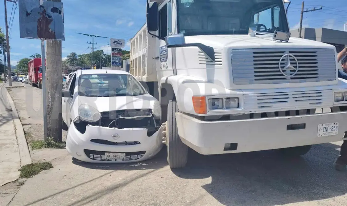Conductor queda atrapado entre camión y poste