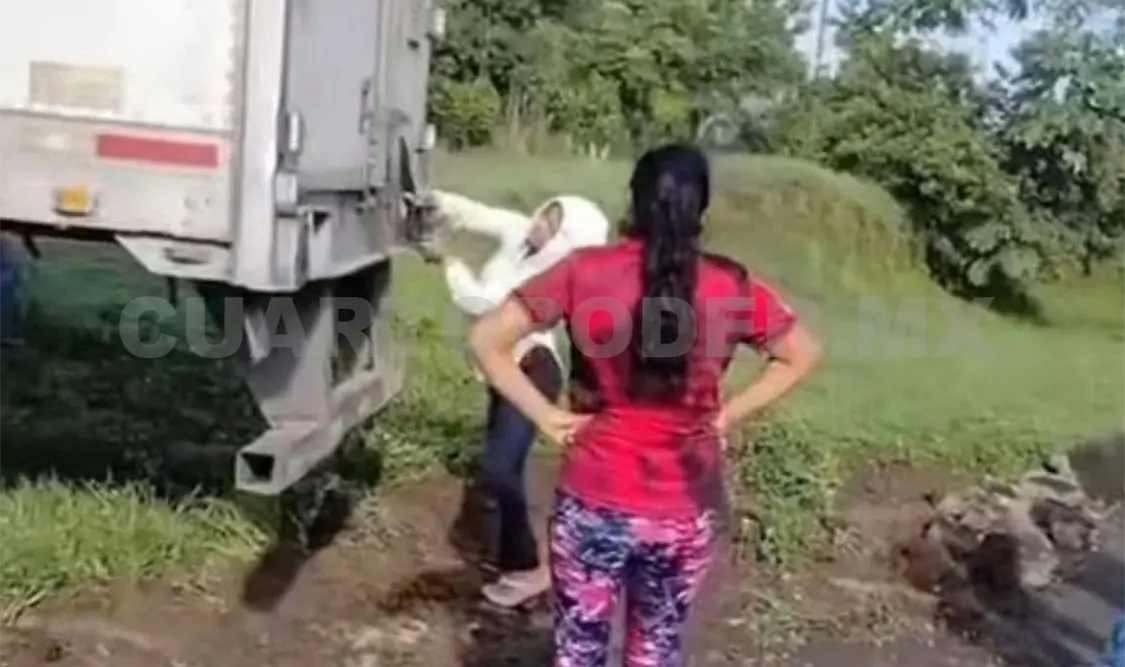 Pobladores se dispusieron a abrir la caja del tráiler con diversas herramientas, como machetes. Jesús Cruz / CP