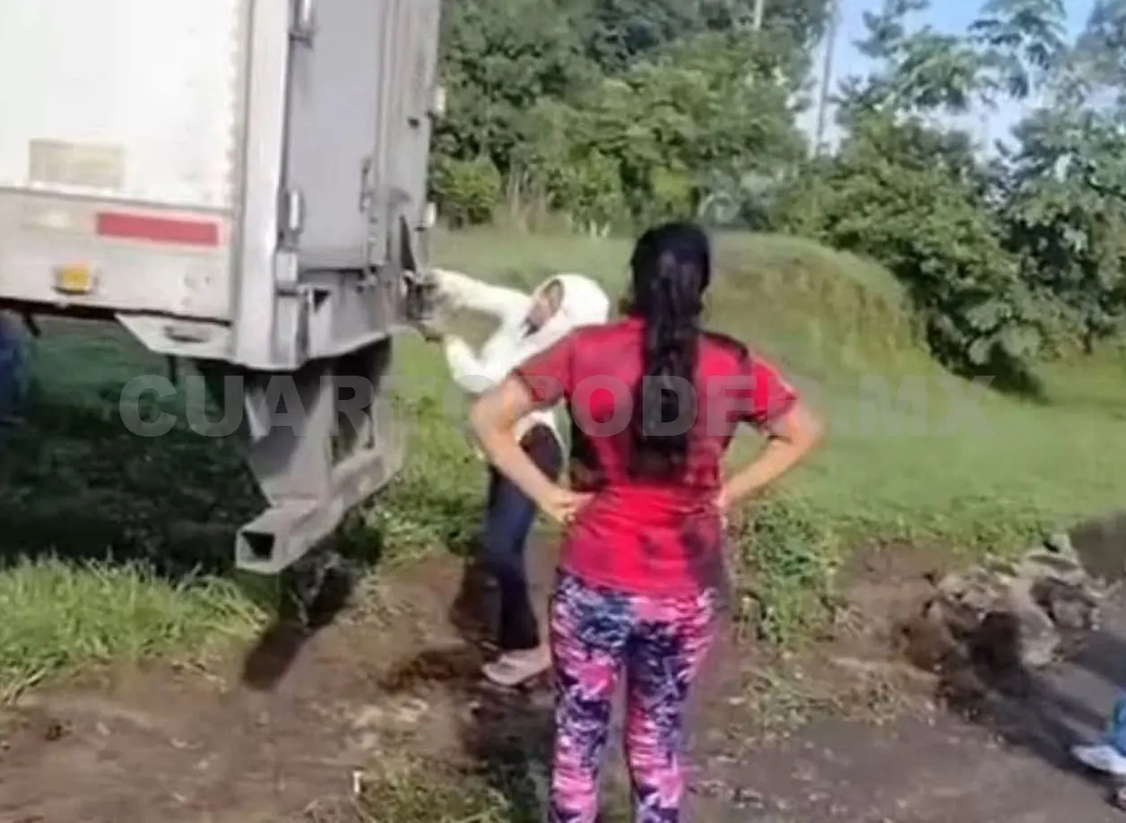 Pobladores se dispusieron a abrir la caja del tráiler con diversas herramientas, como machetes. Jesús Cruz / CP
