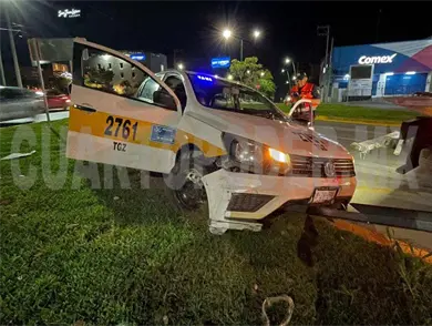 Se impacta y queda atorado taxi en jardineras