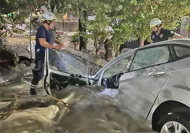 Corriente arrastra a sedán a canal Corriente arrastra a sedán a canal
