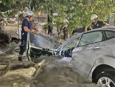 Corriente arrastra a sedán a canal Corriente arrastra a sedán a canal
