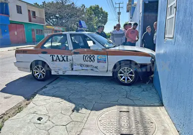 Taxi termina incrustado en portón tras impacto Taxi termina incrustado en portón tras impacto