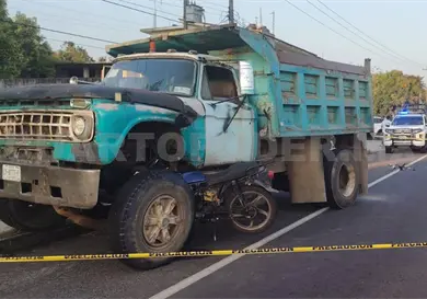 Motociclista se incrusta en volteo