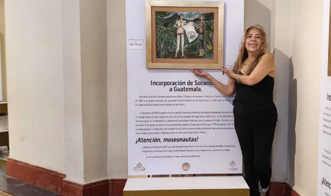 Ángela Tlanextli posando junto a la pintura que donó. Cortesía