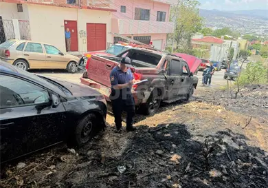 Incendio en terreno bald&iacute;o afecta a par de veh&iacute;culos