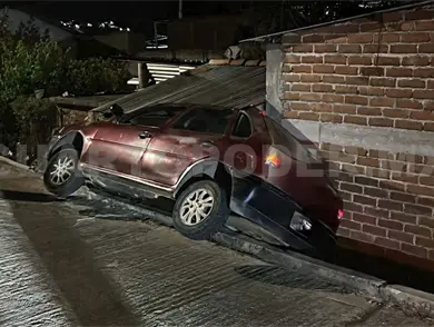 Autom&oacute;vil cae de calle y se estrella en en fachada de casa