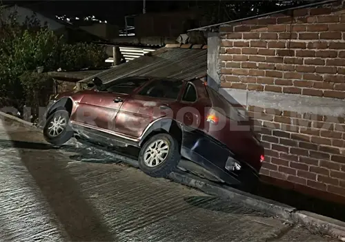 Autom&oacute;vil cae de calle y se estrella en en fachada de casa