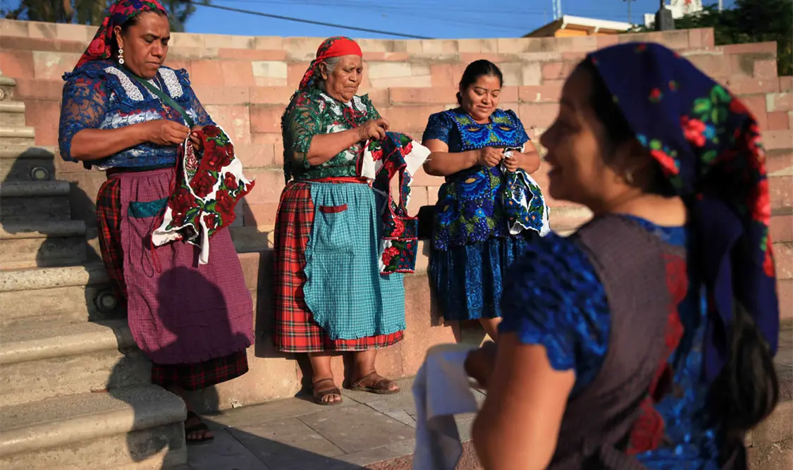 Un vestido de tul plisado, huipil y mandil bordados y la mascada son las prendas clave que distinguen a las mujeres de Quialana. El Universal
